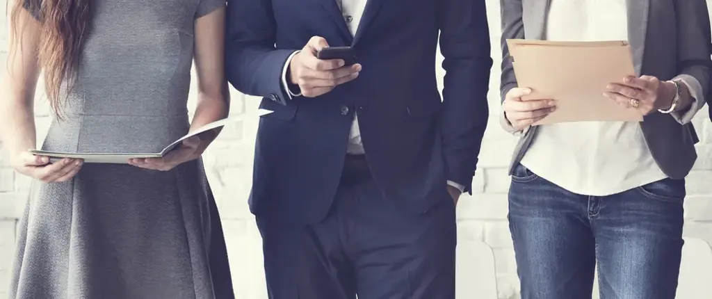 deux personnes avec fichiers et une personne avec portable